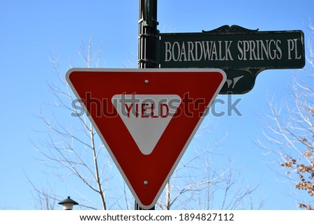 A yield sign next to a street sign that says: “Boardwalk springs place.” Picture taken in O’Fallon, Missouri.
