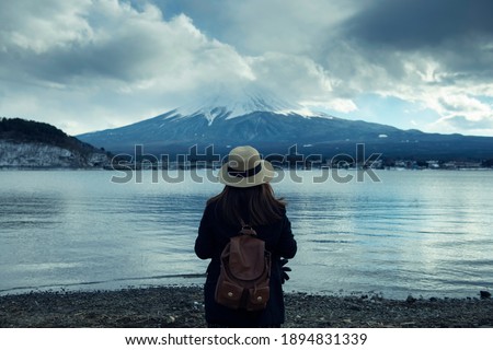 Japanese woman is sightseeing at Fuji mountain at lake Kawaguchiko during winter in Japan.