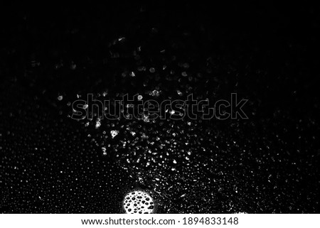 raindrops on glass at night, dark background. black and white texture. defocus and blur. . High quality photo