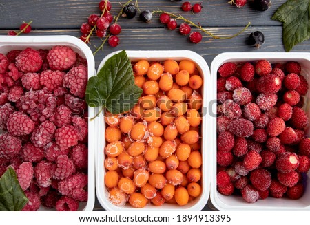 Containers with frozen berries from the refrigerator. Royalty-Free Stock Photo #1894913395