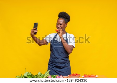 african chef using her phone to make a video with her ingredients