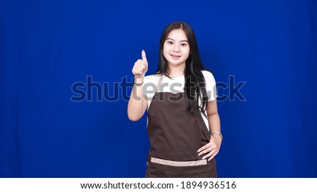 asian woman shopkeeper OK gesture isolated blue background
