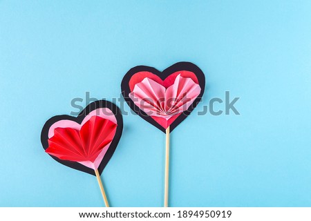 DIY and kid's creativity. Step by step instruction: how to make paper valentine heart on wooden stick. Step6 turn off and glue heart like accordion to  hearts on stick. Craft for Valentines day