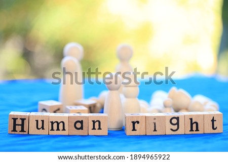 Woman right word in English on wooden block in green bokeh nature as for Woman's day campaign.