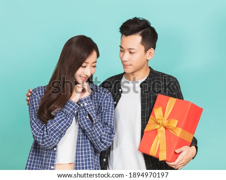 young man giving present to beautiful woman