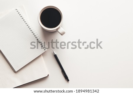 Office desk table with supplies, coffee cup and flower. Top view with copy space
