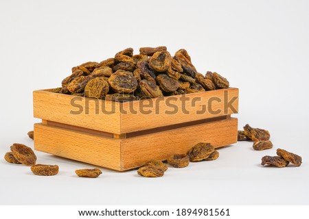 Sun-dried fruits isolated on white.  Naturally sun dried apricot  in wooden box. Copy space. Studio photo. 