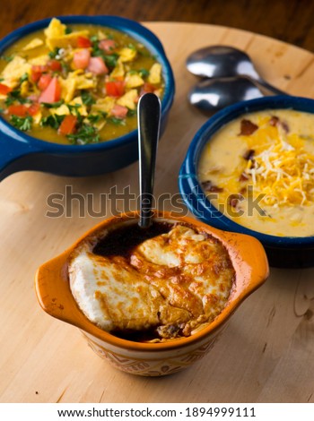 French Onion Soup. Classic traditional french restaurant bistro menu item. French onion soup, yellow onions reduced in broth topped with cheese melted and served with homemade baguettes. 