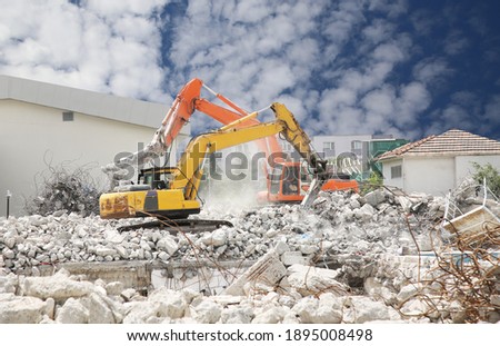 Excavator digs the ground for the foundation and construction. Excavator 
 working demolition site.Heavy excavator with shovel standing on hill with rocks
 Royalty-Free Stock Photo #1895008498