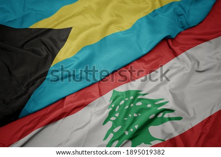 waving colorful flag of lebanon and national flag of bahamas. macro