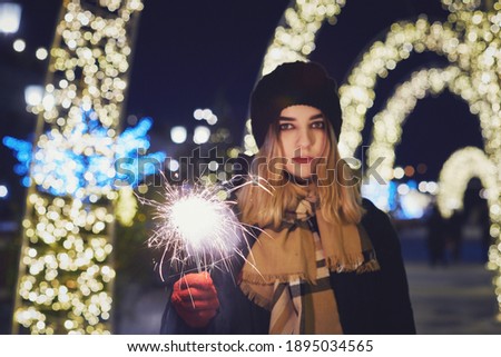 girl with a sparkler on the background of night lights. festive lighting of the city