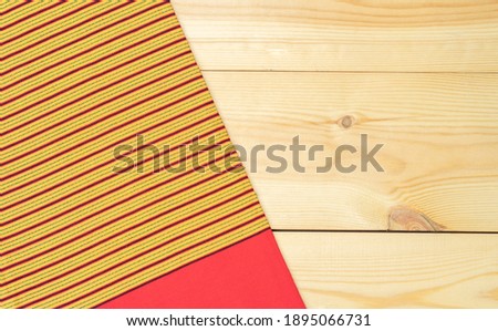 A unique yellow and red patterned sarong in the north of Thailand put on wood background