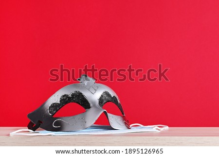 Carnival mask purim and protective medical mask purim on a red background. High quality photo