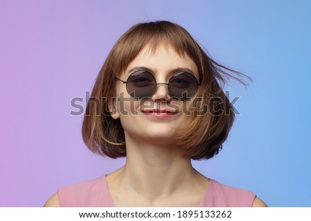 stylish girl in sunglasses. photo shoot in the studio on a pink background