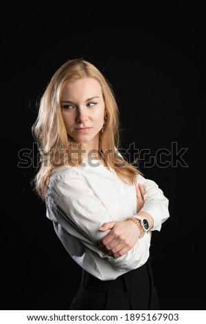 woman stands on a black background in a white blouse. Happy with a lovely smile, in the studio, business woman, blonde