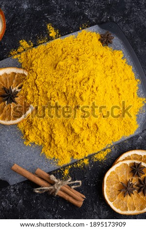 Curcuma (turmeric) spice with dry oranged served at black table. Food and cuisine ingredients. healthy concept. close up. flat lay