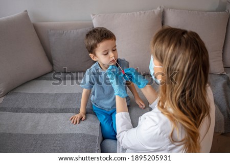 Doctor takes a cotton bud from child’s nose to analyze COVID-19, to determine or presence of virus, SARS-CoV-2 epidemic, coronavirus concept.Doctor takes a cotton swab coronavirus test from child nose