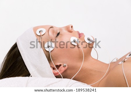 Portrait of a young woman lying  with electrodes on her face Royalty-Free Stock Photo #189538241
