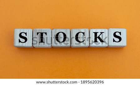 STOCKS - word on wooden cubes on a beautiful yellow background. Business concept