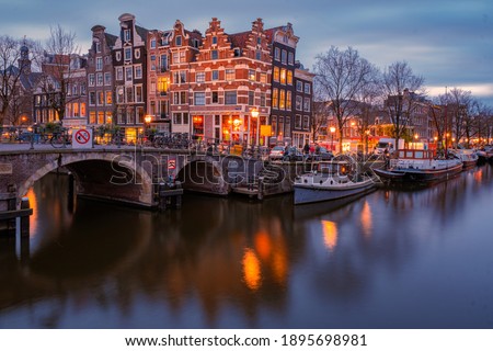 Amsterdam canals Netherlands, Amsterdam Holland during sunset evening during wintertime in the Netherlands. Europe Royalty-Free Stock Photo #1895698981