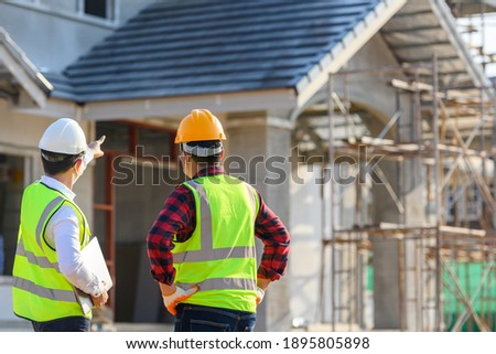 Construction engineer talks to the architect on the construction site. To describe home design work
