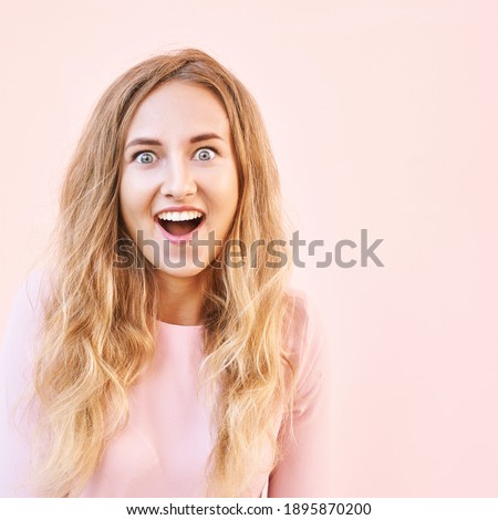 Pretty young woman amazed by sale news. Happy female person outdoors. Summer cute portrait. Lady blonde long hair. Cute adult student at town. Pink background. Copyspace. Wow female emotion