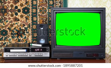 Old black vintage TV with green screen to add new images to the screen, VCR on wallpaper background.