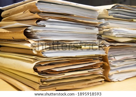 Close-up of piles of files documents in folders stacking up in a messy order. Royalty-Free Stock Photo #1895918593