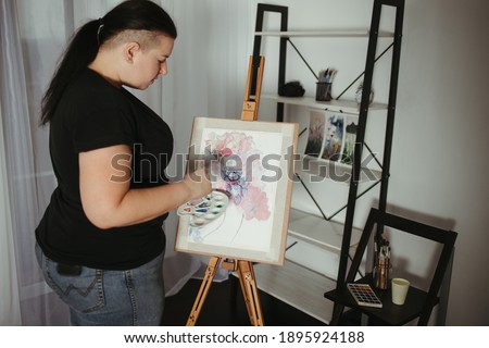 Illustrator, artist or designer at work. Young creative woman standing at home studio with watercolor painted floral pattern sketch