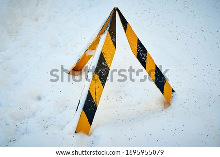 a road sign covered in snow after a heavy snowfall in winter