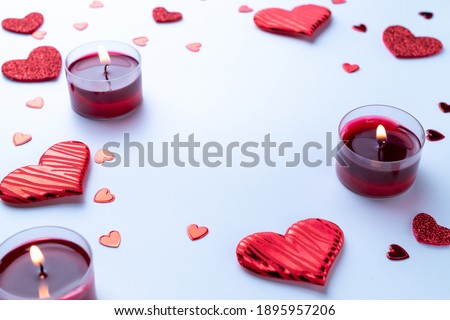 Valentines day background: red love hearts, romantic gift box, candle on white table. February romance present card