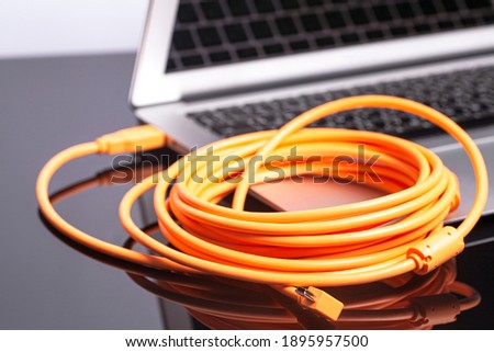 laptop with orange rolled cable.