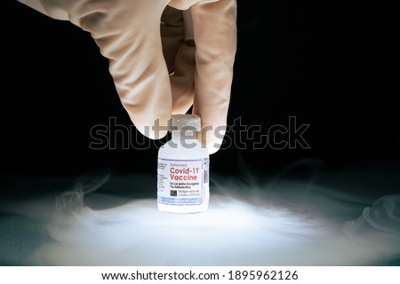 Researcher's hand pick up frozen cold Vaccine vial for Covid-19 with mRNA technology stored in subzero low temperature -70 celsius. Effective thermal controlled for global distribution conditions. Royalty-Free Stock Photo #1895962126