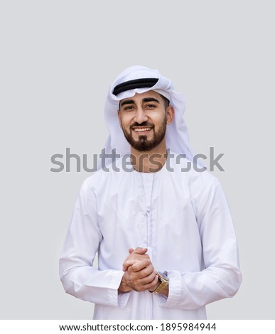 Young handsome Emirati business man in UAE traditional outfit showing a variety of hand gesture. Arabic ambitious mature businessman. Royalty-Free Stock Photo #1895984944