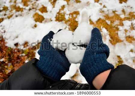 Snowball in child's hand. Navy blue glove. Winter concept.