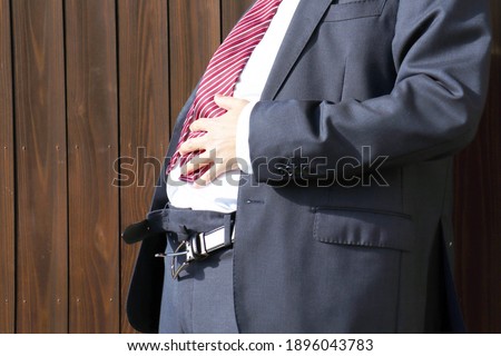 Businessman's belly. Image of obesity. Suit and leather belt. Royalty-Free Stock Photo #1896043783