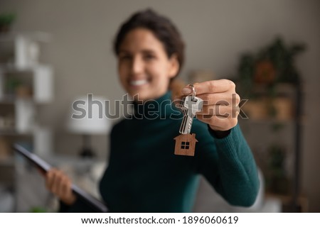 Crop close up of woman real estate agent or broker show keys to new home or apartment. Happy female renter or tenant celebrate relocation moving to own house. Rental, realty concept.