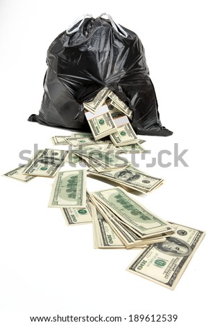 Money in the broken bag / studio photography of black plastic bag with hundred dollar bills on a white background 