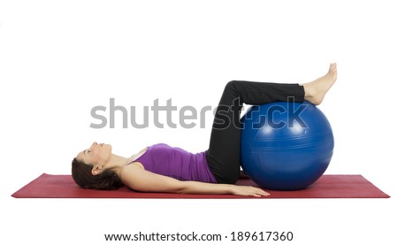 Young woman doing fitness with a pilates ball.