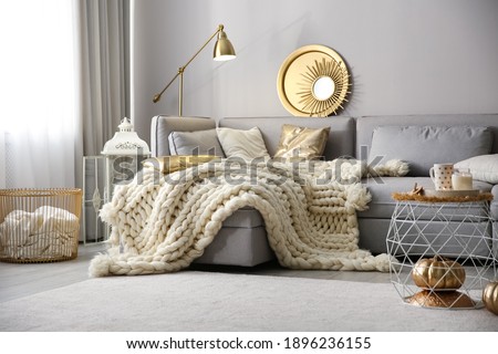 Cozy living room interior with knitted blanket on comfortable sofa Royalty-Free Stock Photo #1896236155