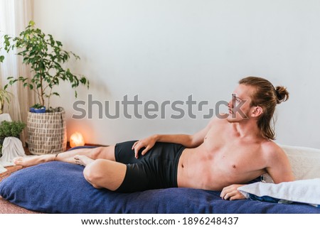 Stock photo of shirtless man lying in the floor and relaxing.