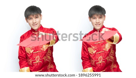 Young Asian man in mandarin collar dress holding red envelope packet on white background with clipping path. Chinese new year concept.