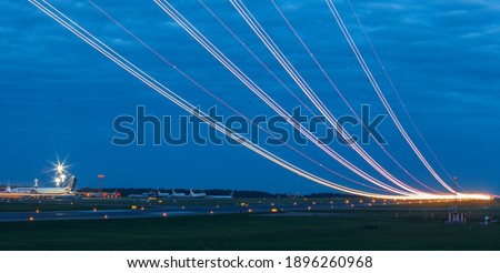 Light trails at airport runway, Against cloudy blue sky at dusk Royalty-Free Stock Photo #1896260968