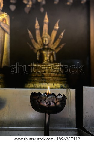 Light a candle to pay homage to the Buddha image for the birthday.
