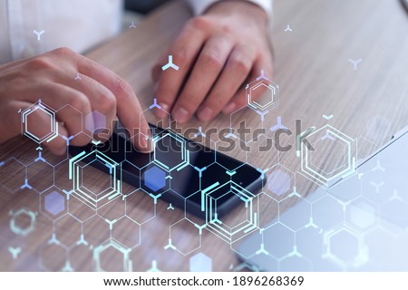 Programmer holding in the hands a smart phone and testing an innovative application to provide a completely new service. Close up shot. Hologram tech graphs. Concept of Dev team. Formal wear.
