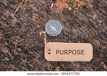 Conceptual Image: Magnetic compass with paper tag written PURPOSE in close up.