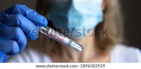 PCR test for corona virus, swab collection kit in doctor hands close-up, panoramic view of nurse in medical mask holding COVID-19 PCR tube. Concept of coronavirus diagnostics, test result and health.