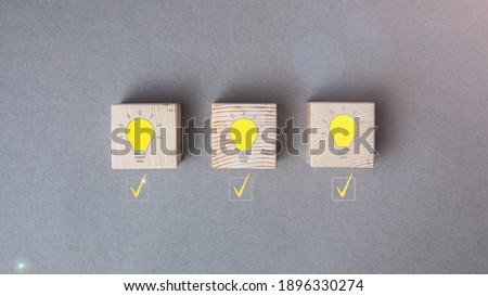 Creative idea, new idea, innovation and solution concept. wooden cubes with yellow light bulb symbol on the table, gray background, copy space
