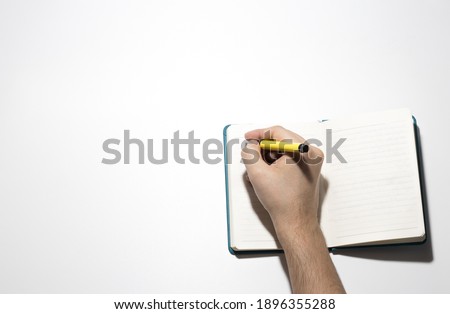 man writing in the notebook