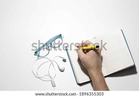 man writing in the notebook